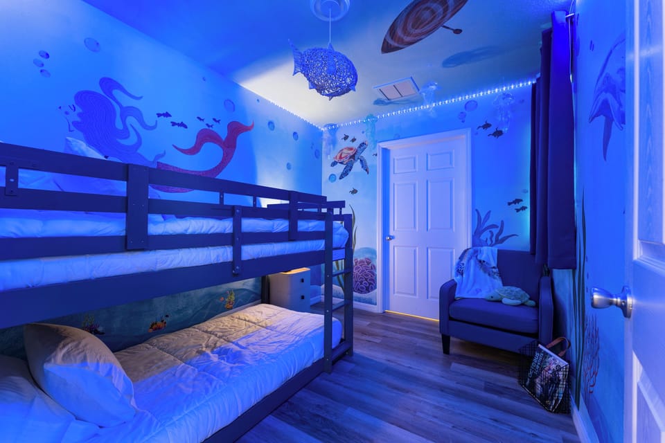 Watch the kids claim the Underwater Bunk Cove as theirs as soon as they walk in. With two twin beds tucked beneath a mermaid, a sea turtle, and a drifting boat overhead, plus a cozy chair for reading stories, this is the room for sweet dreams. 