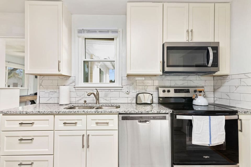 Embrace modern elegance with sleek white cabinets and stainless steel appliances, offering the perfect blend of style and functionality