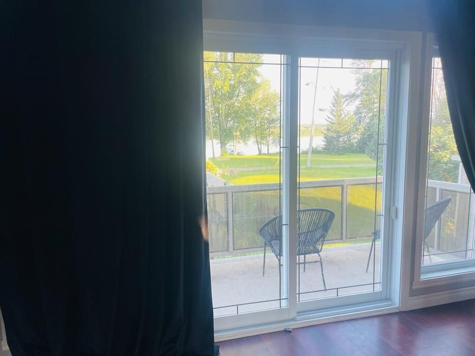 Balcony near the dining table, features 2 wicker chairs and a view