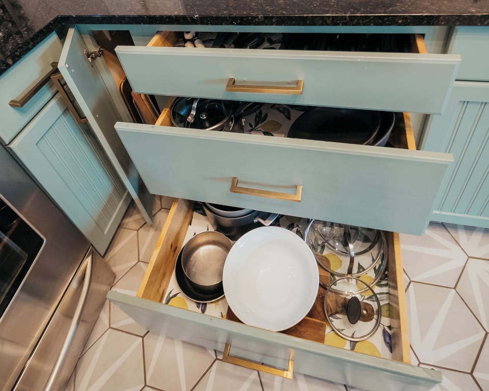 Many pots and pans, mixing bowls and kitchen tools