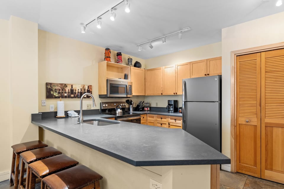Your spacious kitchen features sleek countertops, modern appliances, and comfortable bar seating perfect for morning coffee or casual dining together.
