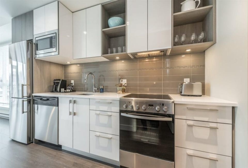Fully equipped kitchen galley complete with full-sized stainless steel appliances, electric range, dishwasher, and built-in microwave.