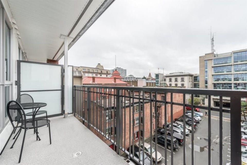 Private covered outdoor balcony with table seating overlooking the surrounding city block.