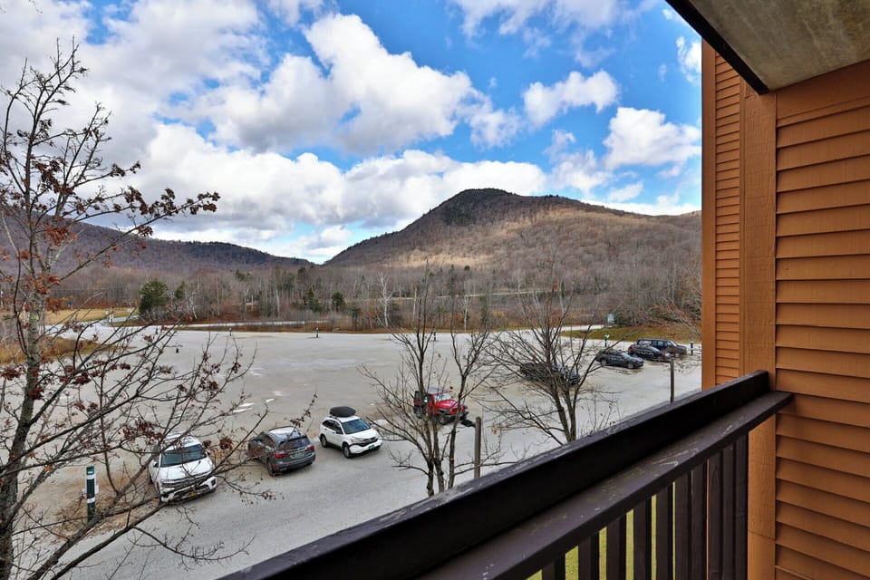 The balcony faces across the parking area toward the hills beyond.