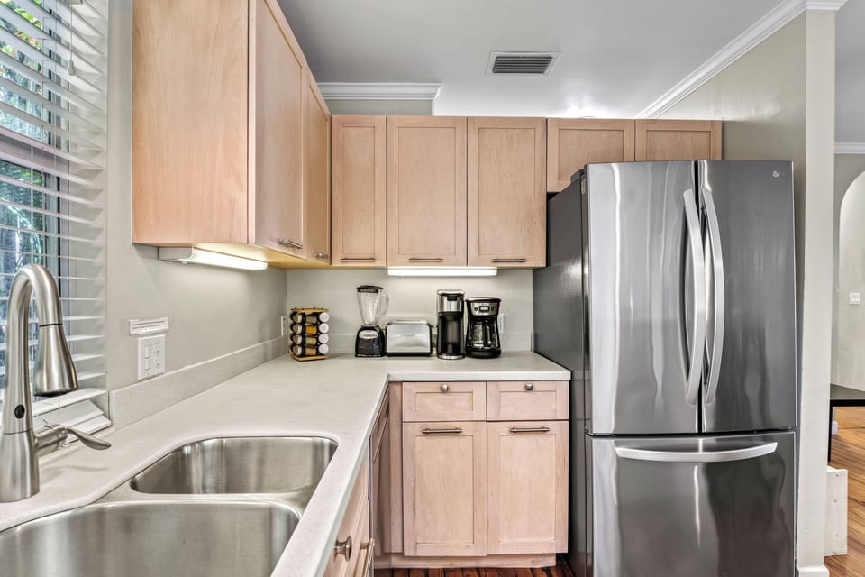 Your morning ritual starts here—brew your favorite roast with a Keurig or drip setup, surrounded by bright cabinetry and beachy charm.