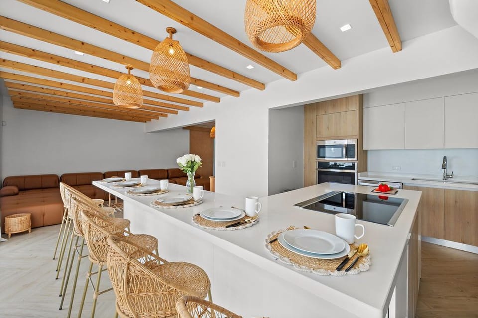 This modern indoor dining area combines sleek, contemporary design with a refreshing tropical vibe. The clean lines of the dining table and chairs , like rattan and bamboo accents, which bring a hint of the tropics indoors.