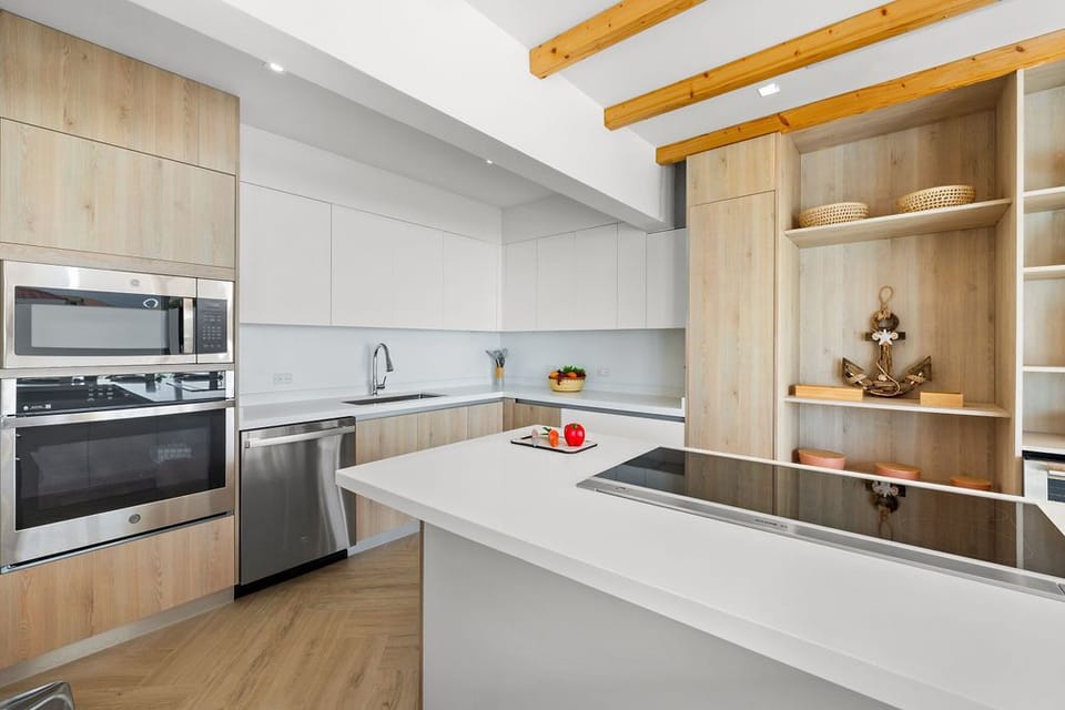 This modern kitchen is a perfect blend of style and functionality, featuring sleek cabinetry, high-end stainless steel appliances, and a spacious countertop.