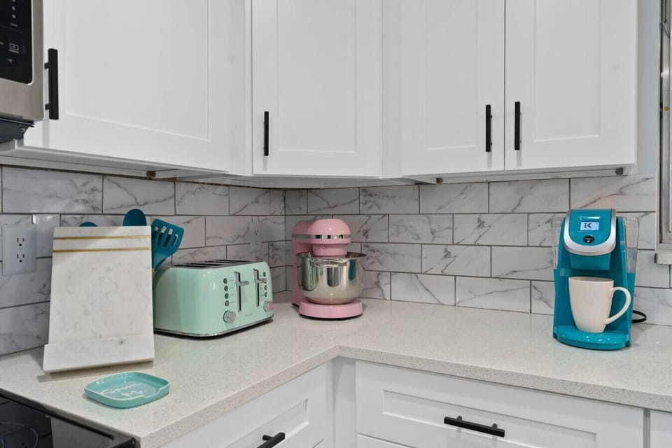 Retro kitchen counter with vintage-inspired teal toaster, pink KitchenAid stand mixer and teal Keurig coffee maker, Vivid Vintage Orlando