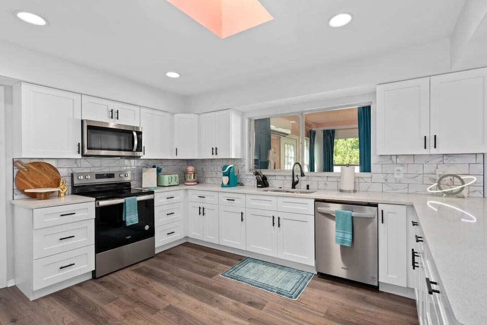 Clean retro-style kitchen with white shaker cabinets, subway tile backsplash, stainless appliances and teal accent dish towel, Vivid Vintage Orlando
