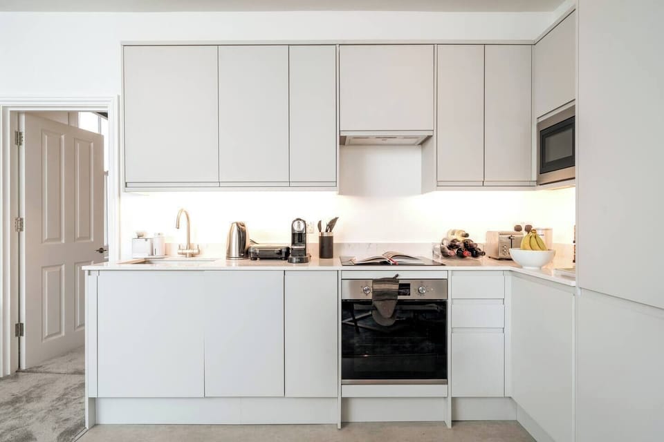 The kitchen features sleek white countertops and cabinets providing a clean and modern aesthetic. The induction cooker offers precise and efficient cooking, allowing you to prepare your favorite dishes with ease. 