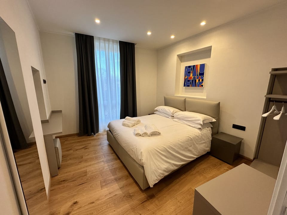 Bedroom with double bed, mirror, console table and open closet