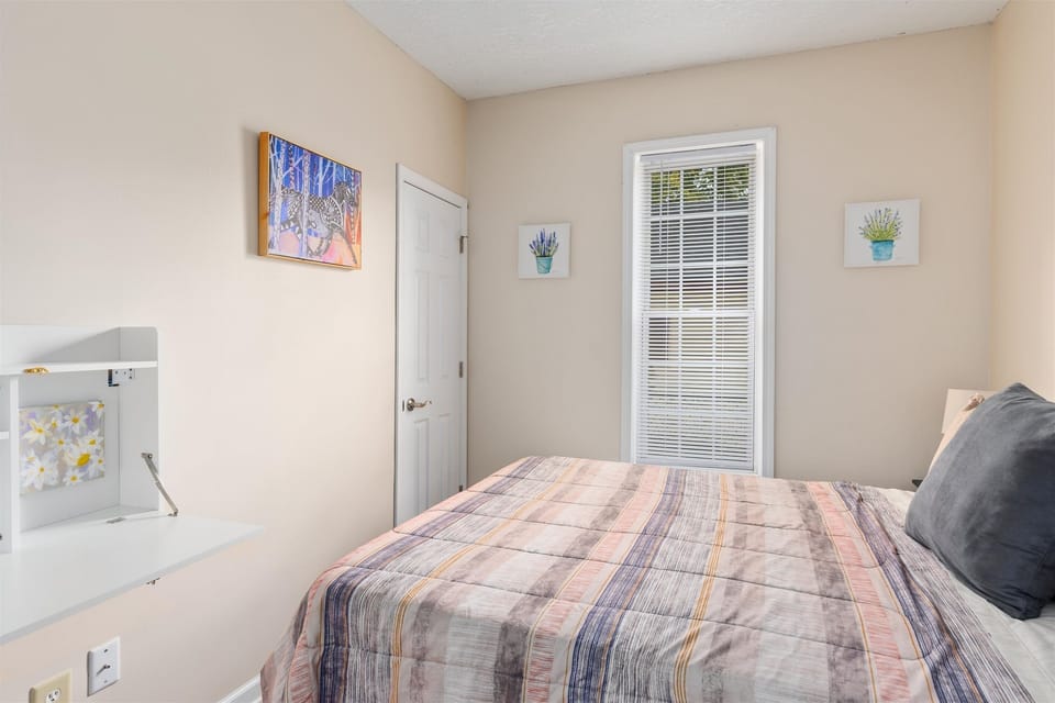This cozy downstairs bedroom offers a wall desk and queen bed.