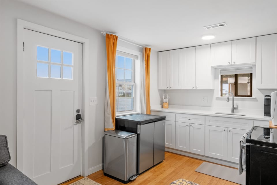 Countertop dishwasher and small fridge with freezer in unit.