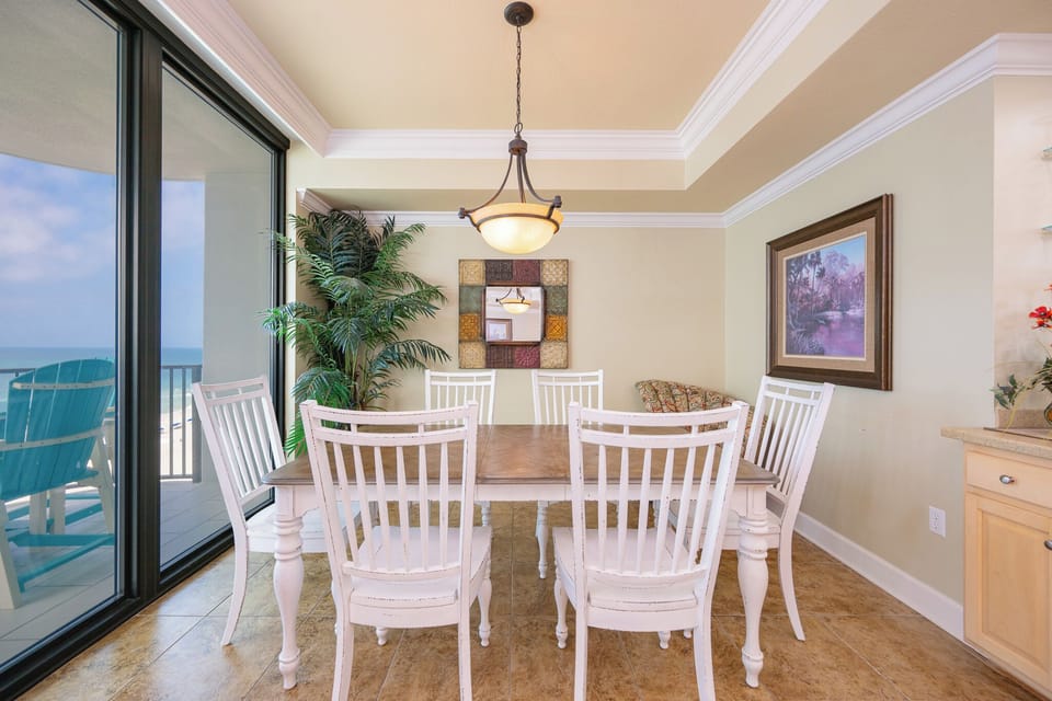Dine comfortably at the dining table surrounded by stylish chairs, with views just beyond the large windows