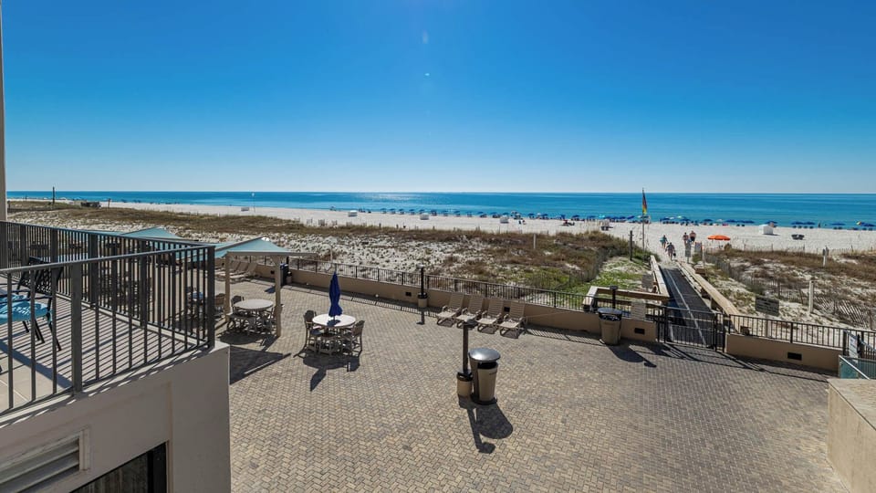 Enjoy the spacious outdoor pool area with seating and easy access to the beach for a relaxing day in the sun