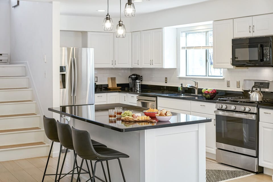Spacious kitchen with island, stainless-steel appliances, and cooking supplies.