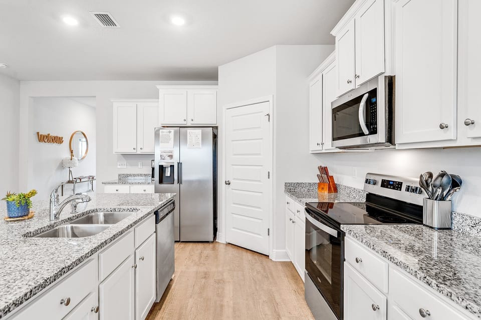 Your spacious kitchen boasts granite countertops, stainless steel appliances, and crisp white cabinetry perfect for preparing memorable meals.