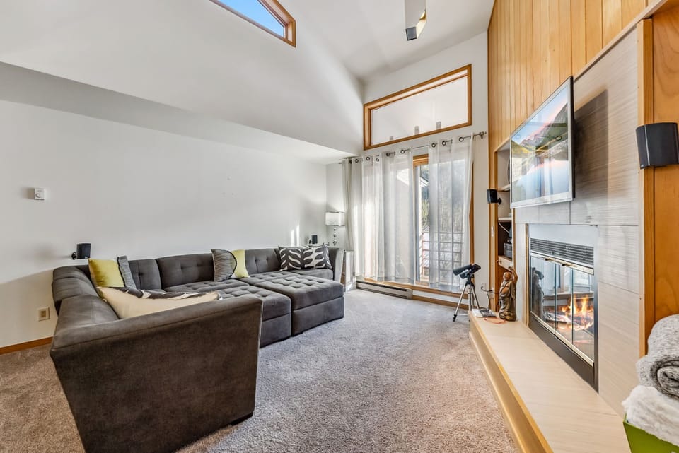 Living Room: Plush oversized couch, 55” Smart TV with cable TV, gas fireplace, access to balcony
