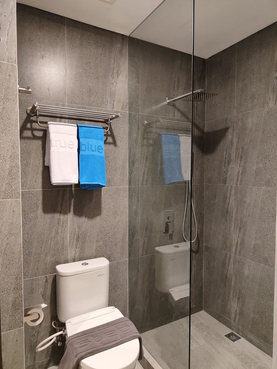 Shower, rainfall showerhead, slippers, towels