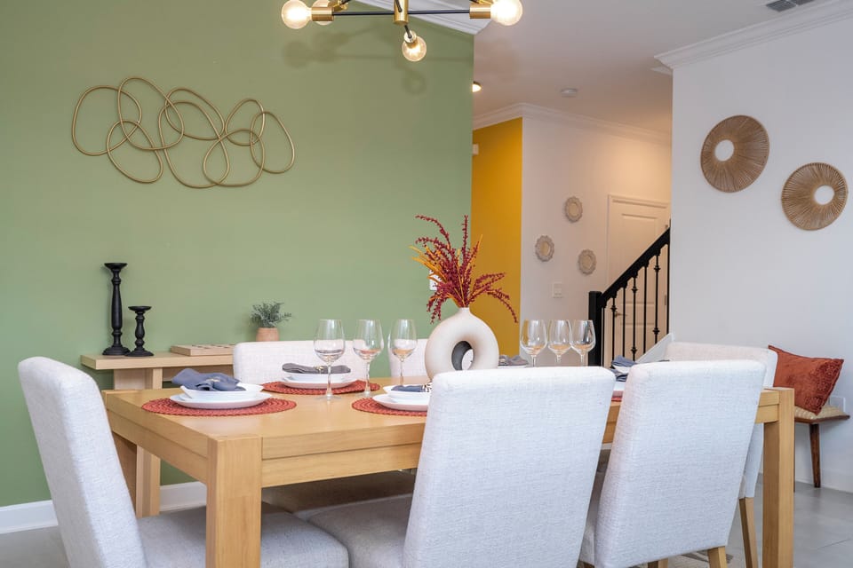 The modern dining area features a sleek table with six chairs, perfect for shared meals and gatherings in a stylish, inviting space.