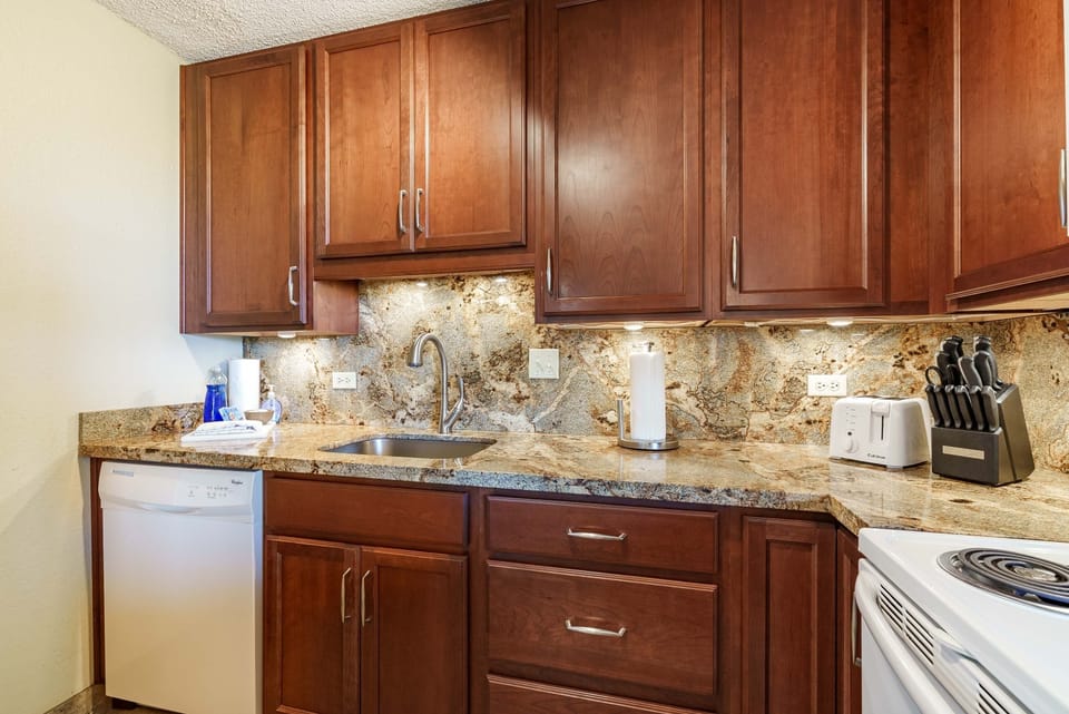 Fully stocked kitchen with granite countertops and modern appliances.