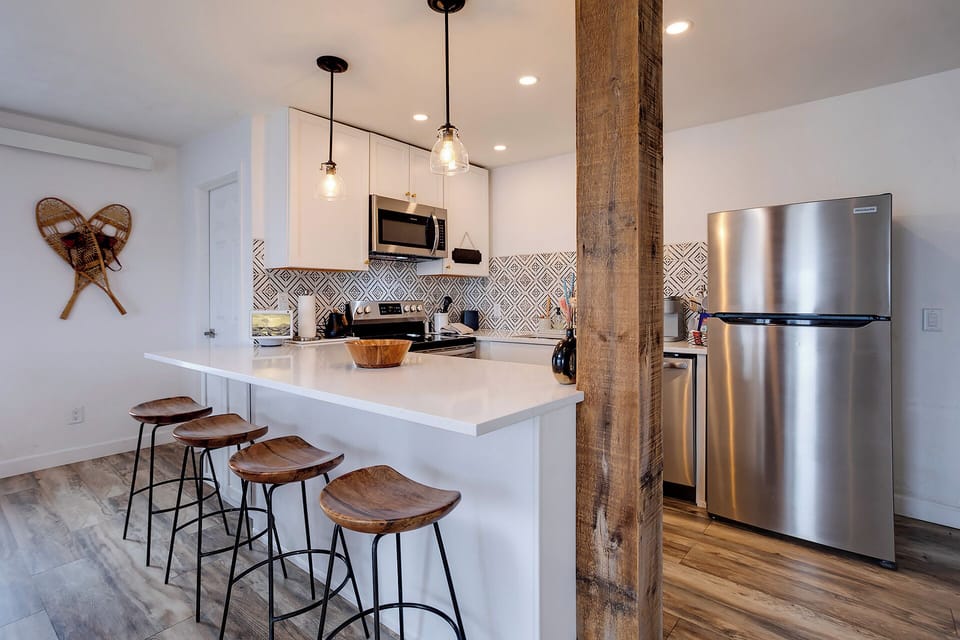 Your modern kitchen blends rustic charm with sleek appliances, featuring a breakfast bar where you can savor morning coffee surrounded by warm wood accents.