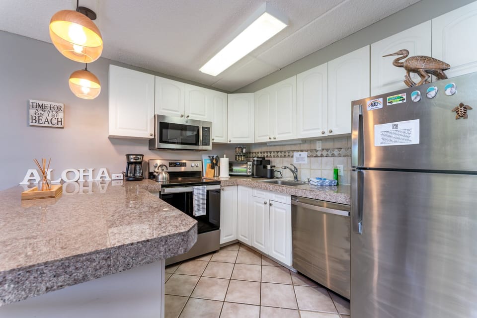 Modern kitchen with stove/oven, mocrowave, dishwasher, fridge, coffee maker, toaster and many more