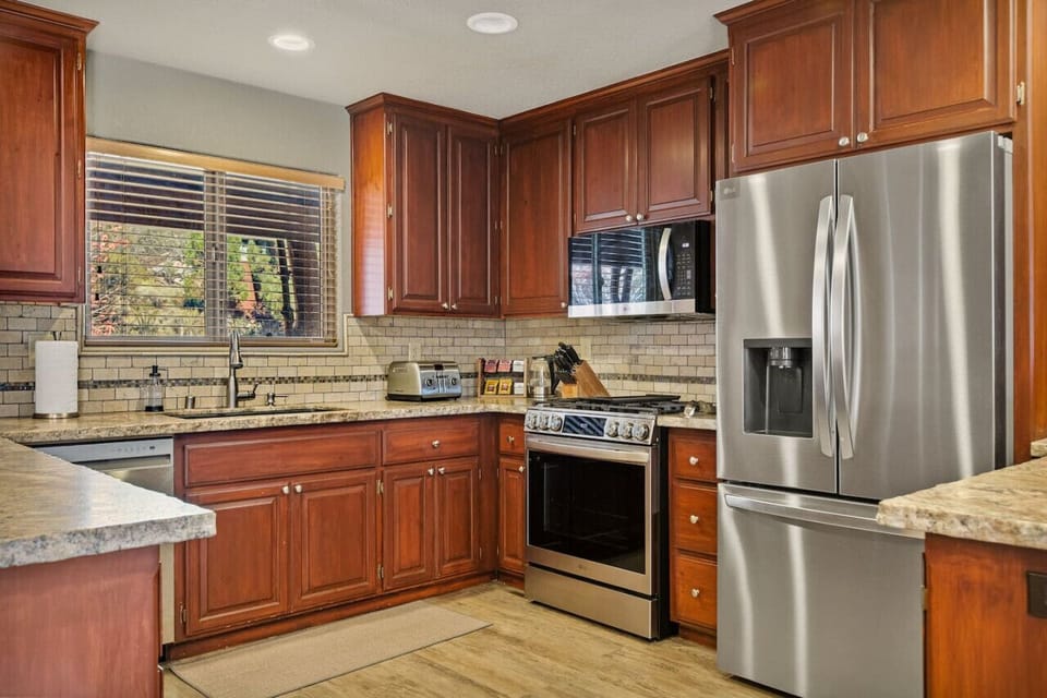 The kitchen comes fully equipped, boasting generous counter space perfect for family gatherings, complete with a breakfast bar.