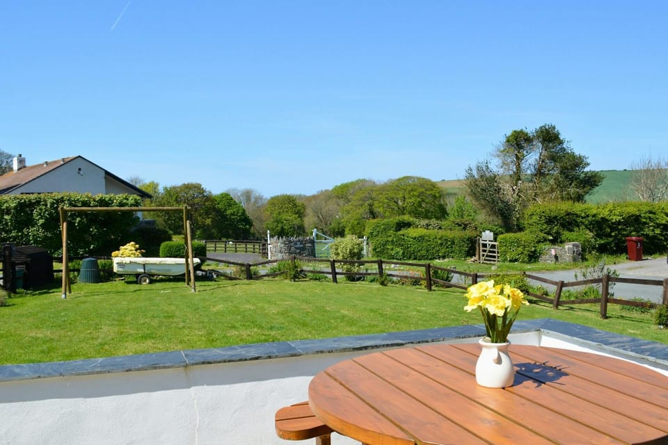 The outside of Carreg Coetan Cottage with outdoor table and lawn