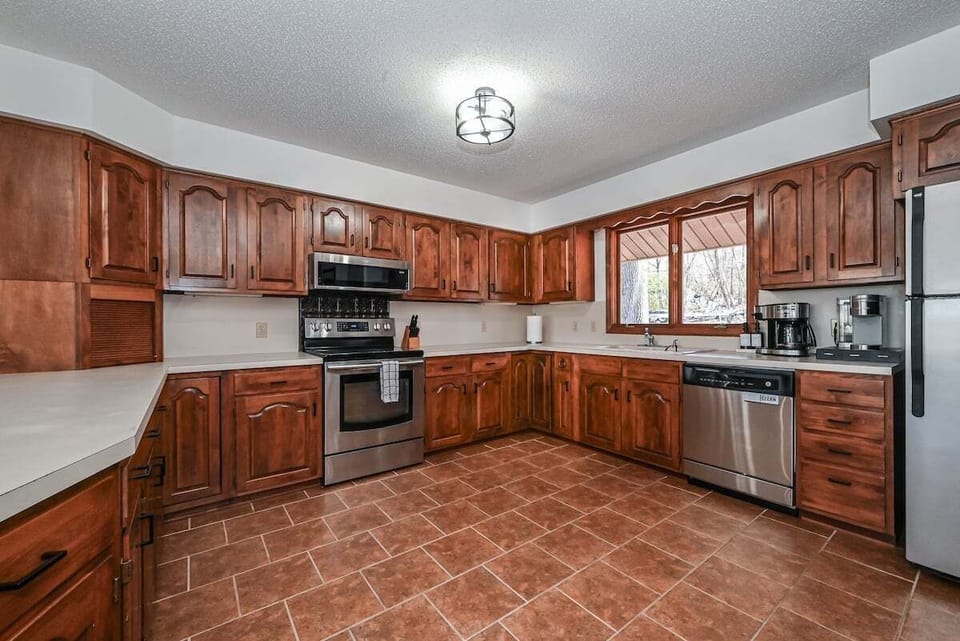Fully equipped kitchen includes dishwasher, gas stove, and coffee station.