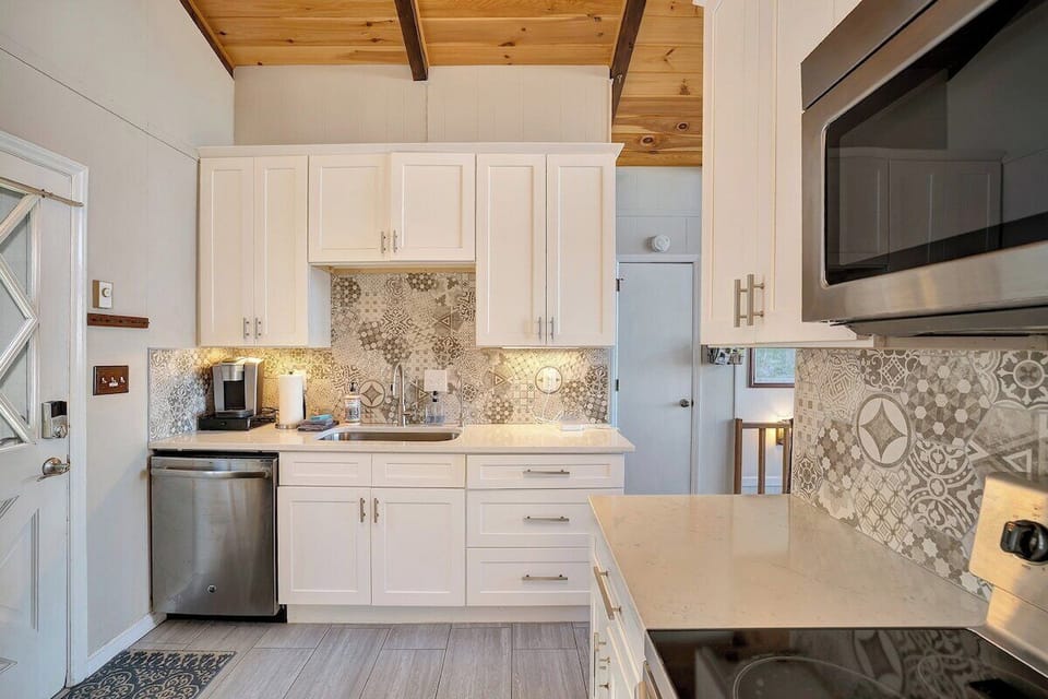Gather and create in this sleek kitchen space, featuring rich wood tones, modern appliances, and a layout perfect for both quiet breakfasts and group feasts.