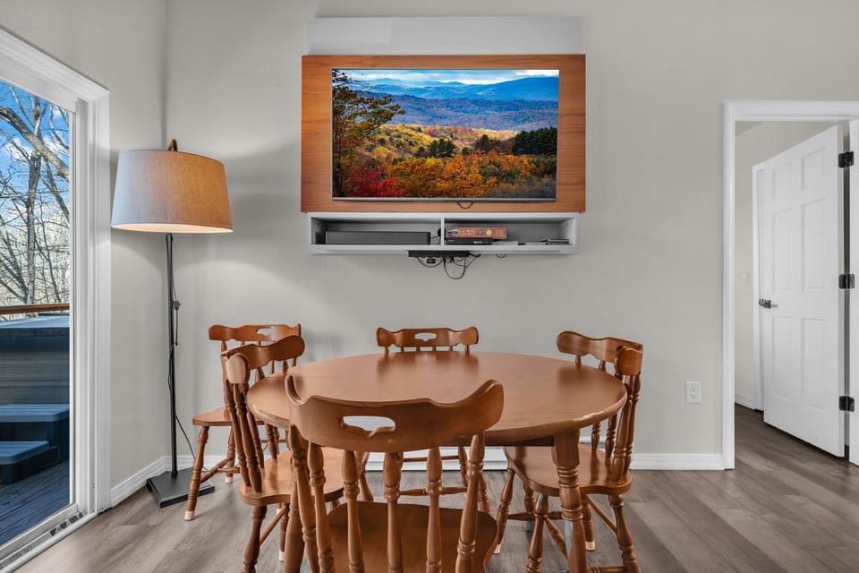 Charming dining space with large windows and woodland scenery, perfect for shared meals and game nights.