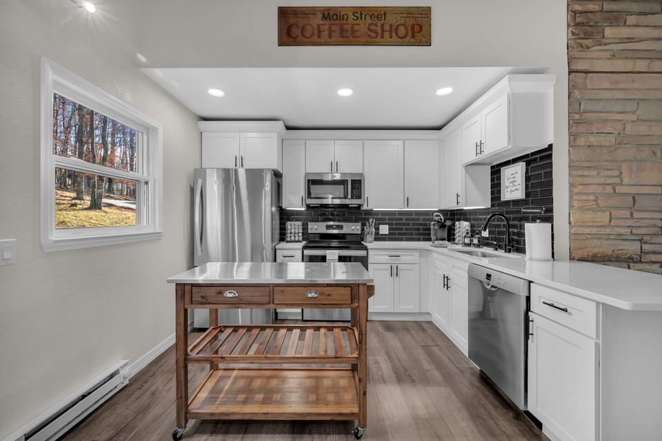 Spacious kitchen with stainless appliances, coffee maker, toaster, cookware, and plenty of counter space.