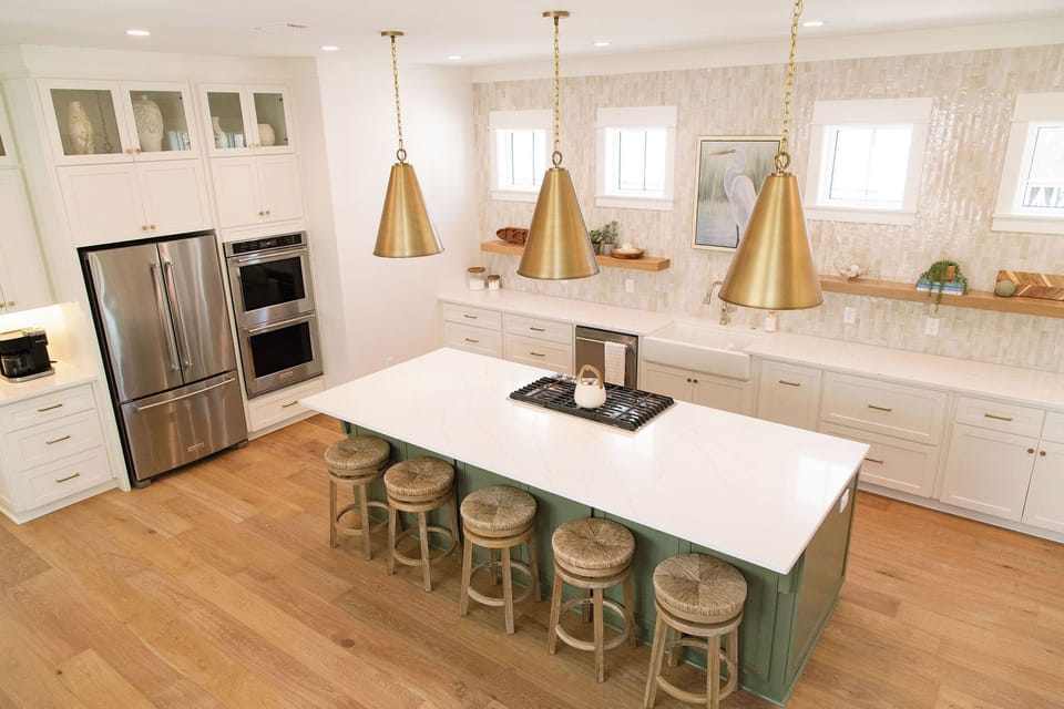 Gourmet kitchen with gas cooktop, double ovens, fridge, and dishwasher. 