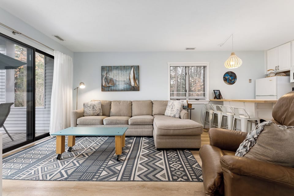 Bright open living area w/ cozy seating & large windows for easy gathering.