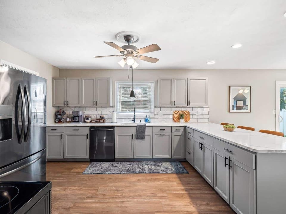 Open kitchen w/ wraparound counters, subway tile backsplash & ample cabinet storage