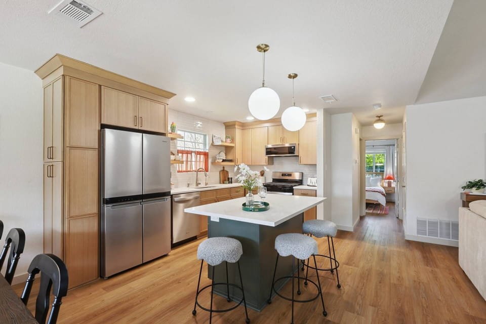 Fully stocked kitchen with stainless steel appliances and bar stool seating at the counter
