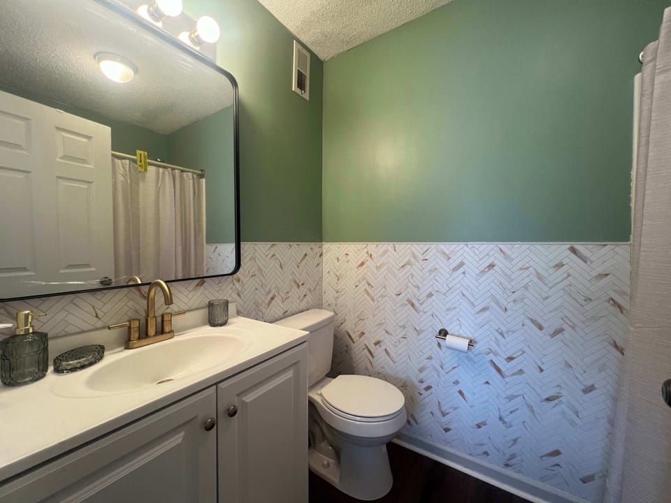 Wash up in the ensuite, featuring a single vanity & shower/tub combo