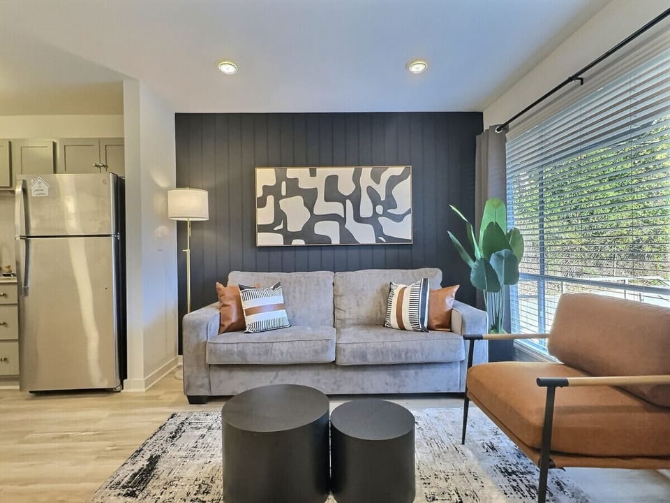 An elegant living area in Downtown Birmingham that blends modern design, natural light, and cozy touches for the perfect stay.