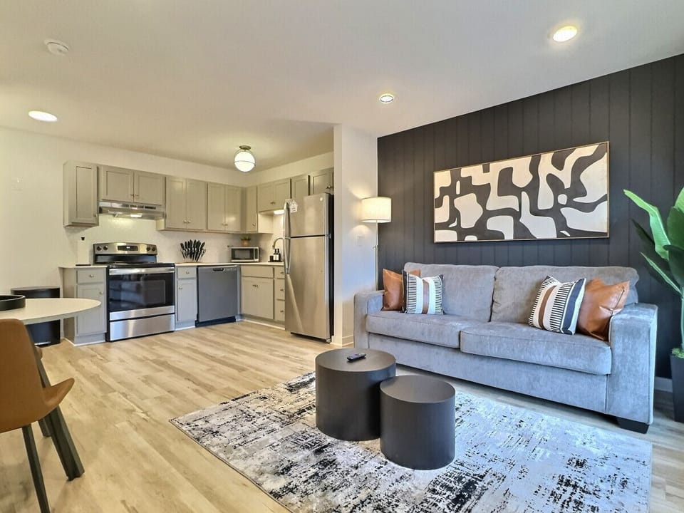 This open-concept living area in our furnished apartment combines style and functionality. With a cozy couch, a lovely dining set, and modern kitchen amenities, it’s an ideal spot for gathering, entertaining, or simply enjoying a quiet movie night.