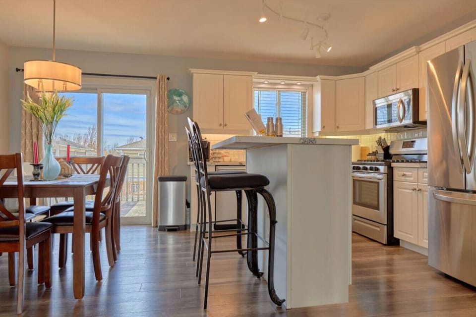 Open concept kitchen/dining room for cooking and entertaining. Upper deck patio table with umbrella and natural gas BBQ.