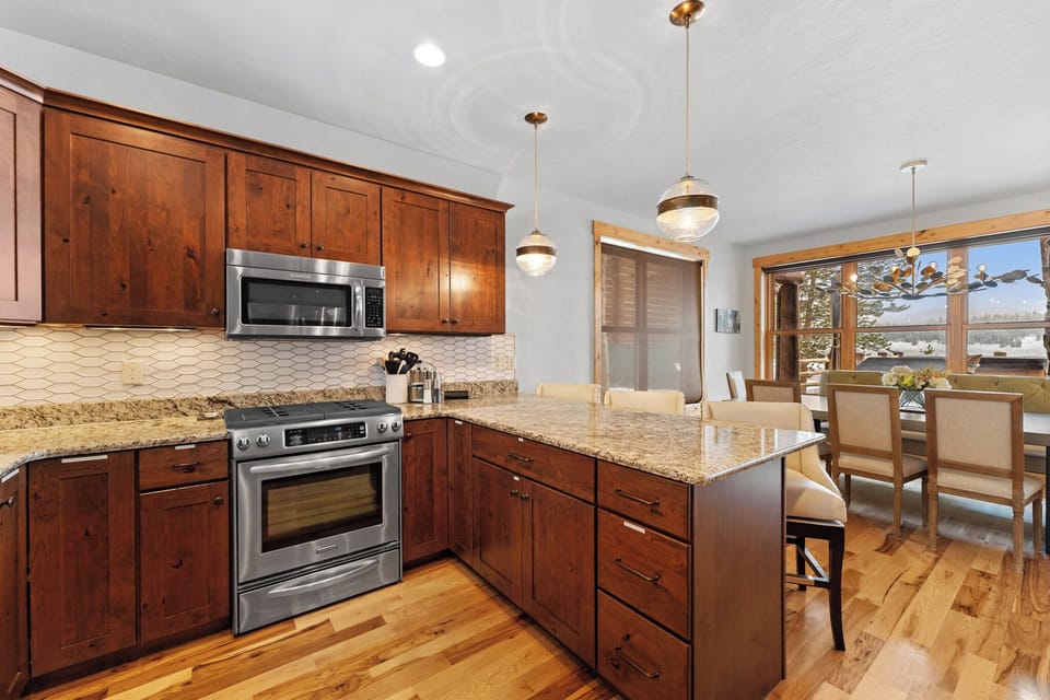 Full kitchen with stainless steel appliances, and breakfast bar seating 3.