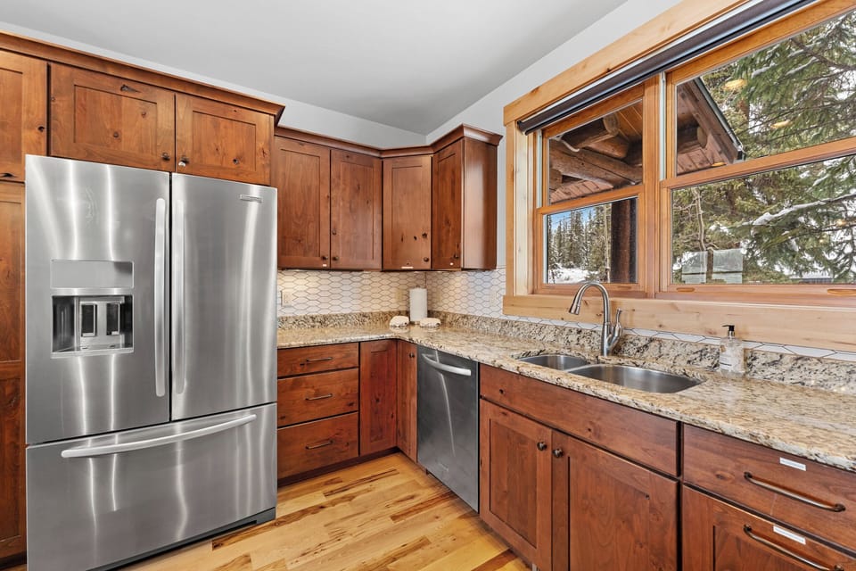 Full kitchen with stainless steel appliances, and breakfast bar seating 3.