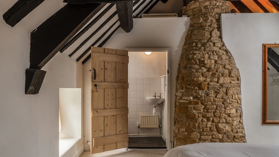 The en-suite is split across the chimney from the fire below