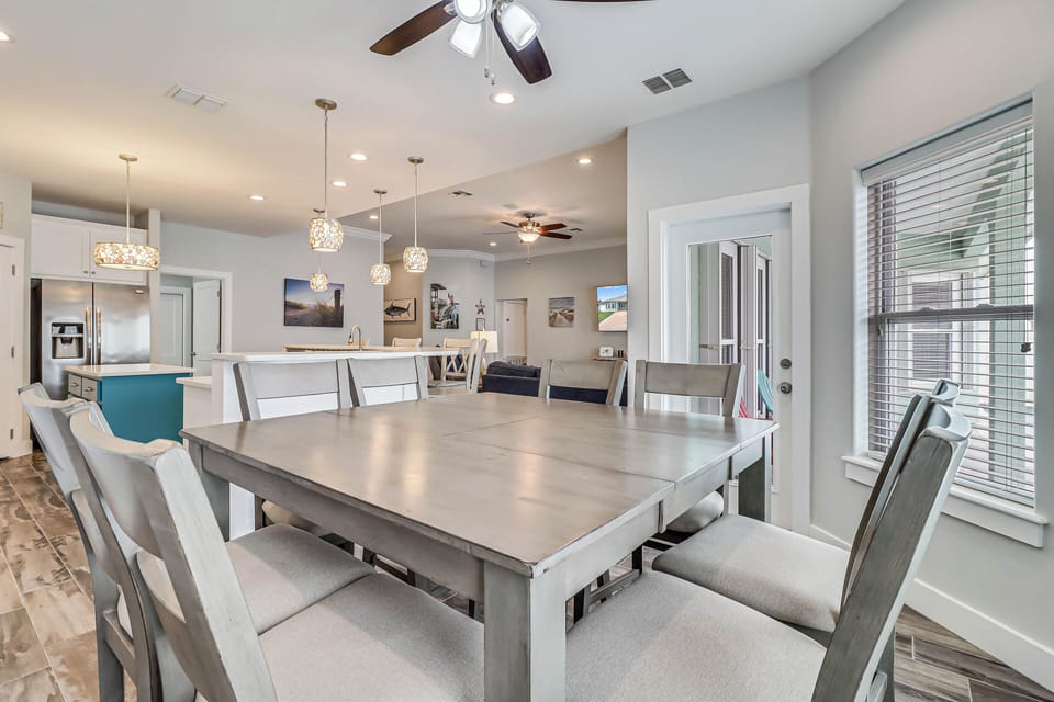 Gather around your spacious dining table where elegant pendant lights create warm ambiance for memorable meals with loved ones.