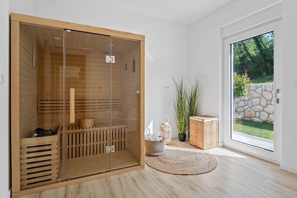 A relaxing Sauna room with a door toward the outdoors and the pool area