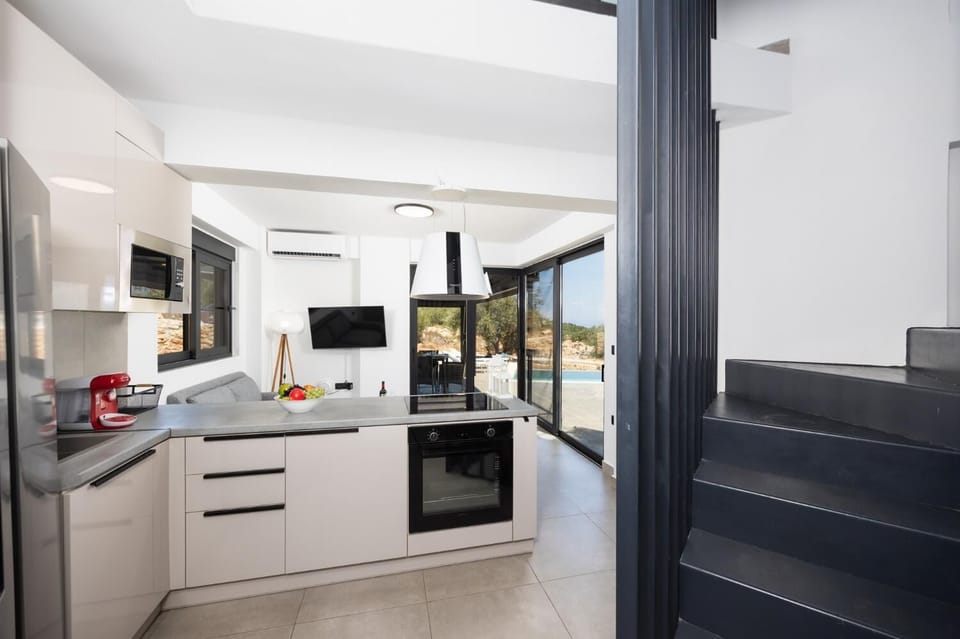 Open-plan living room with sofa, kitchen, A/C, WiFi internet, and satellite TV