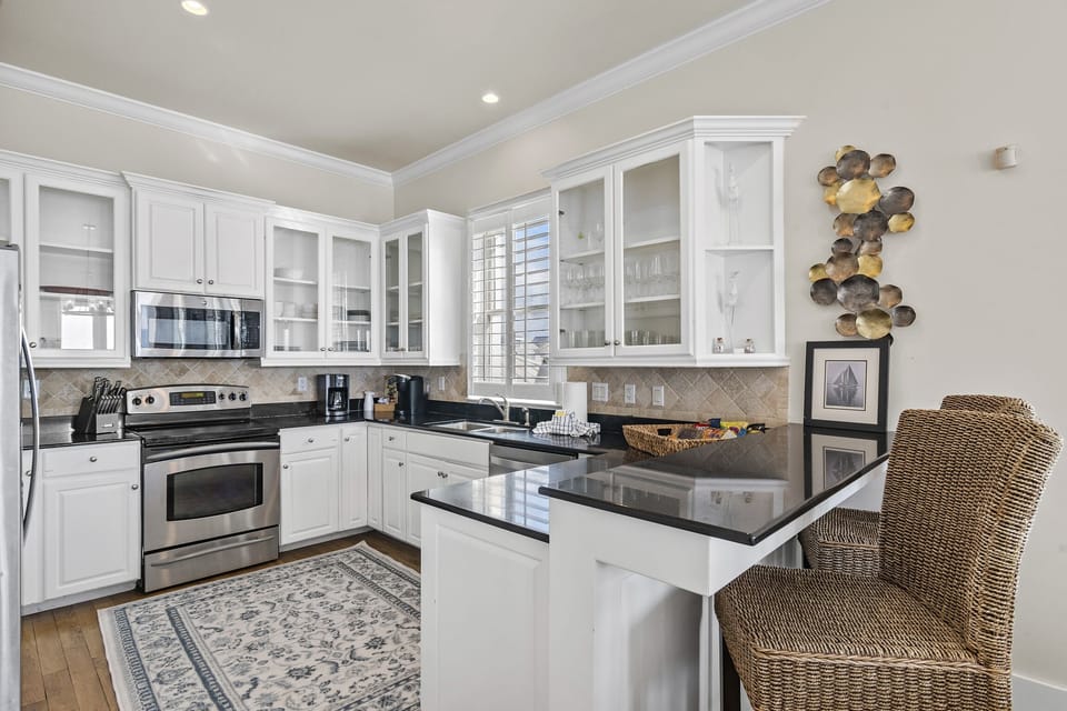 Remodeled Kitchen with granite countertops, stainless appliances - cook delicious meals and dine while overlooking the Gulf of Mexico!