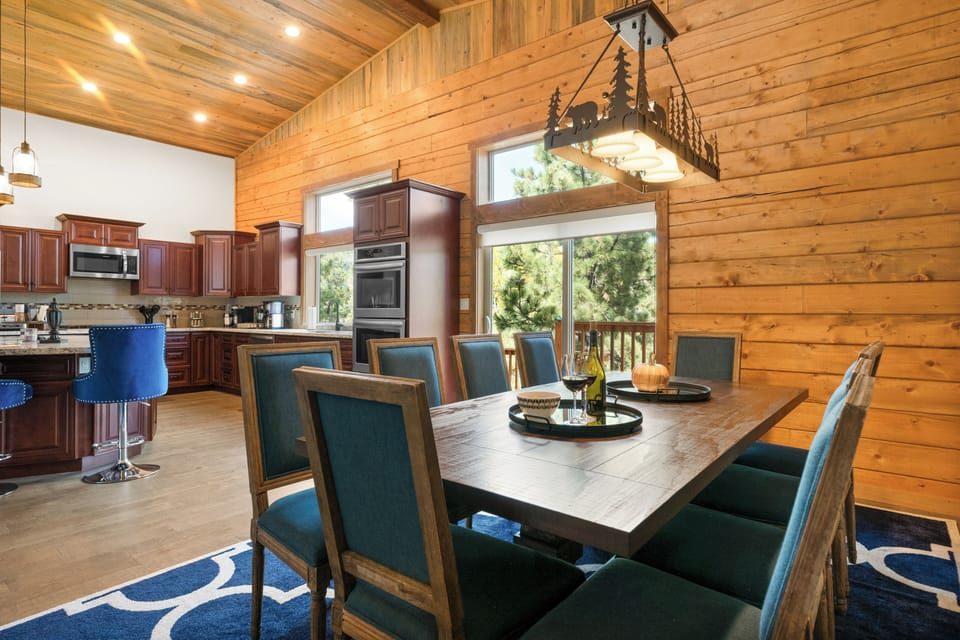 The large dining table is located adjacent to the kitchen, making serving easy. 
