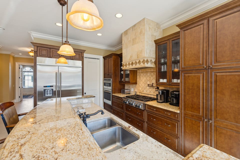 Kitchen amenities include 6-burner gas range with pot filler faucet,  Large refrigerator with ice maker, Double oven and wine fridge